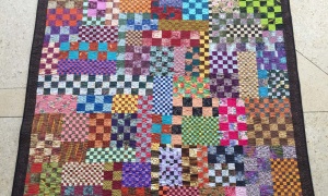 Charu Patel, Kenya. 'Finishing Line' quilt. As the race to find a vaccine for COVID-19 gathers momentum, I am sitting by the sideline making masks for charity. The remnants are pieced to make quilts.